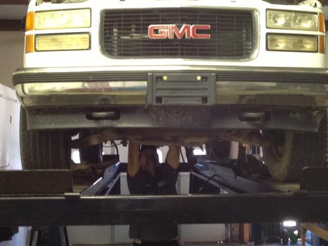 Hydra-Tech Transmissions - mechanic working on the underside of a GMC truck